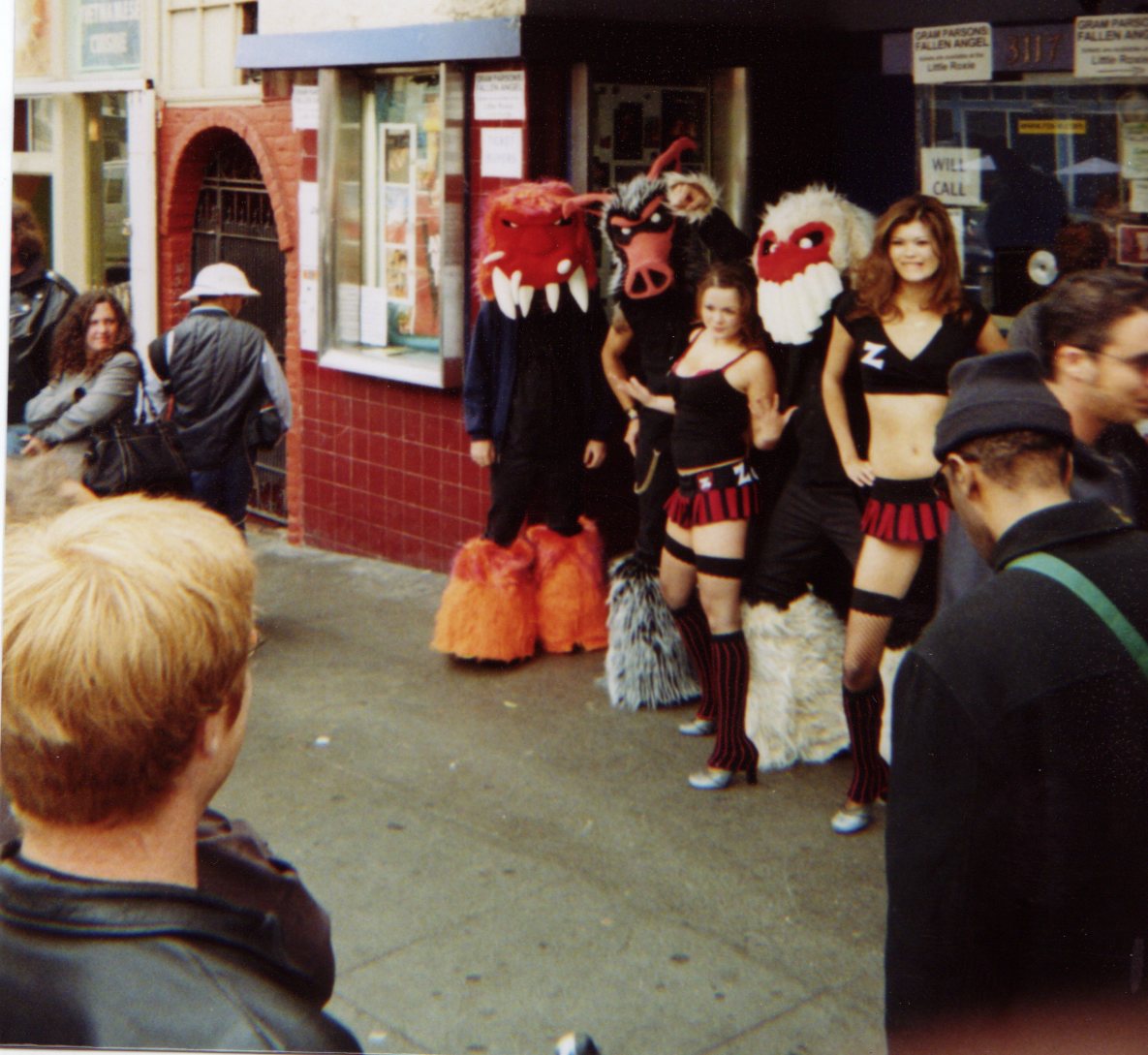 Costumed puppet characters and two performers posing on the sidewalk outside the Roxie.
